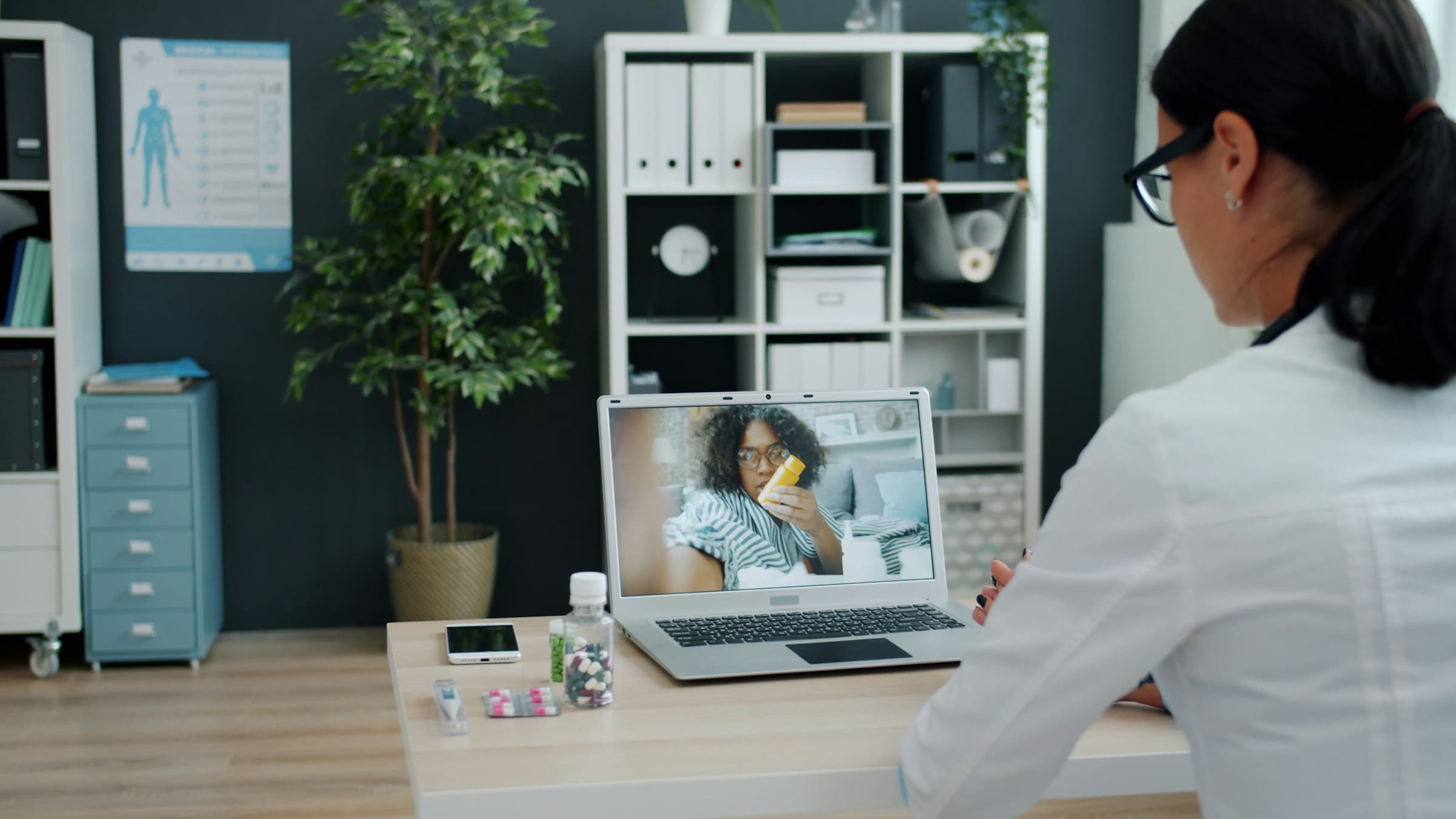 A doctor in her consulting room on a video call with a patient