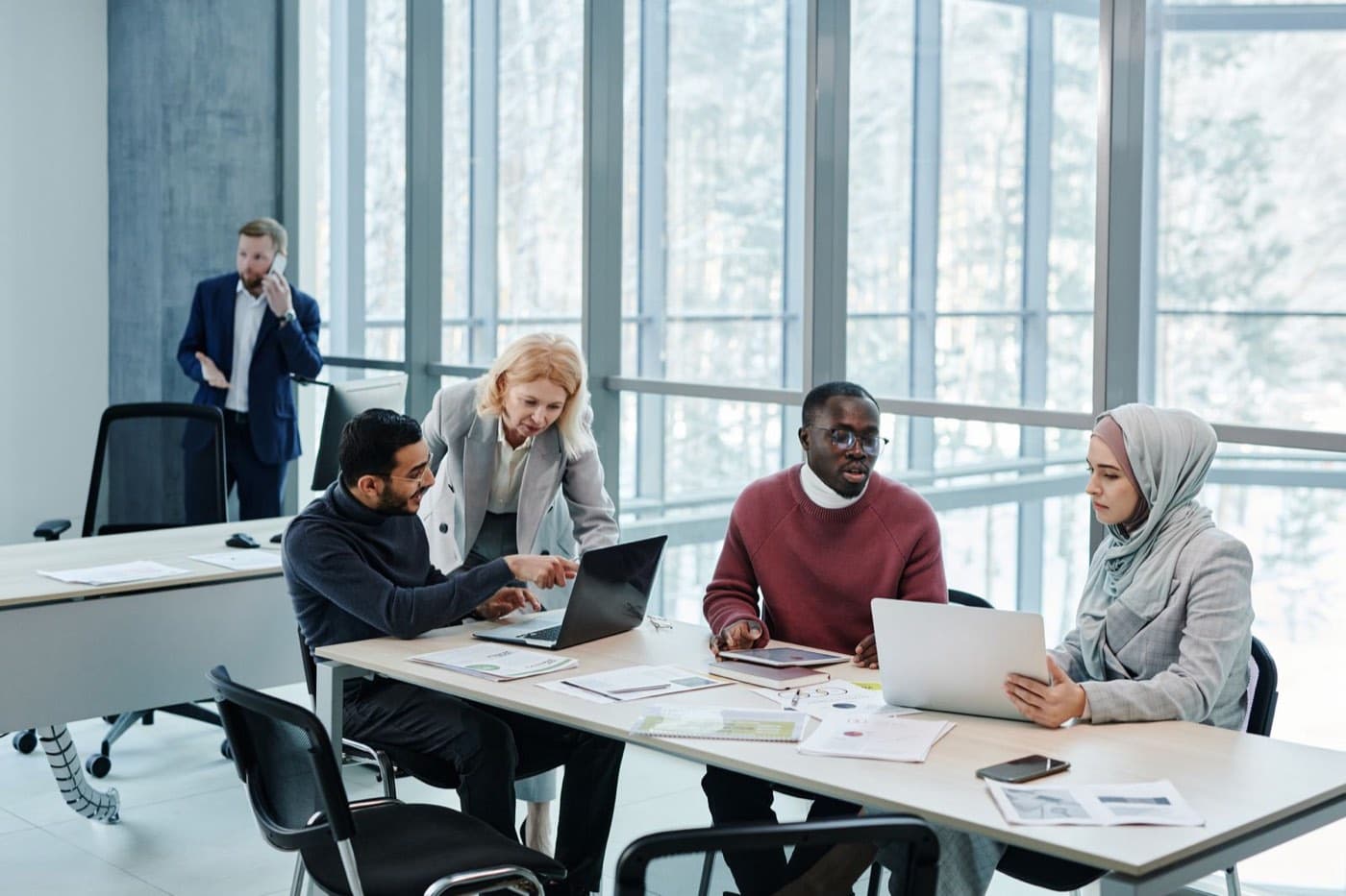 Colleagues of different backgrounds working together at a shared desk